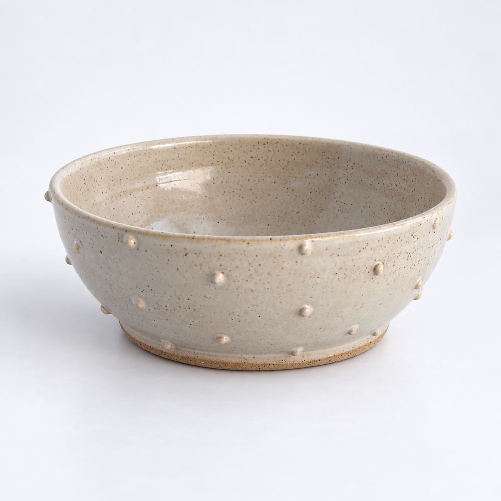 Ivory ceramic serving bowl with dotted surface